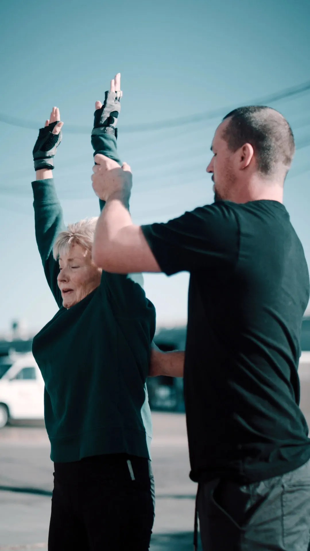 Coach assisting a member with mobility stretching